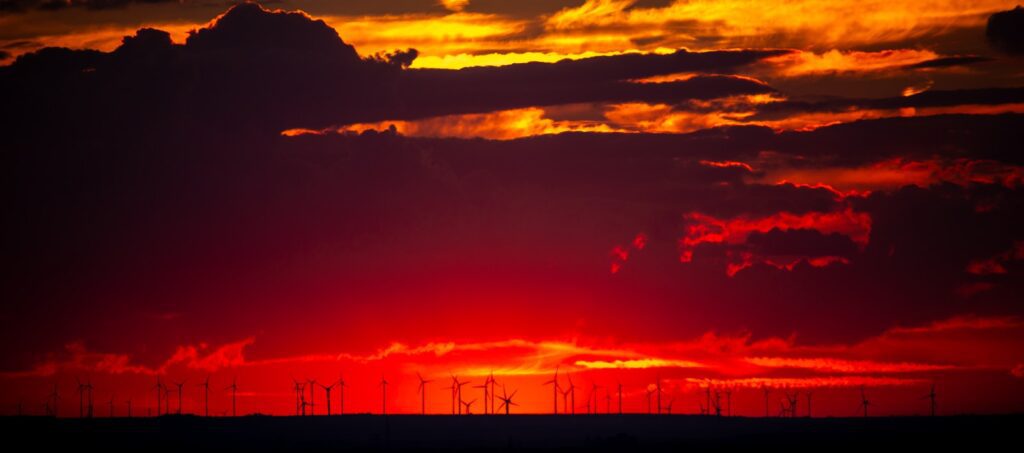 The sun is setting over the horizon of a field